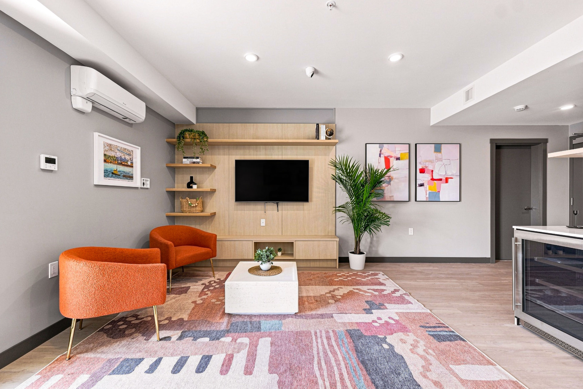 First & Royal resident amenities lounge with seating, TV wall, and modern decor, New Westminster
