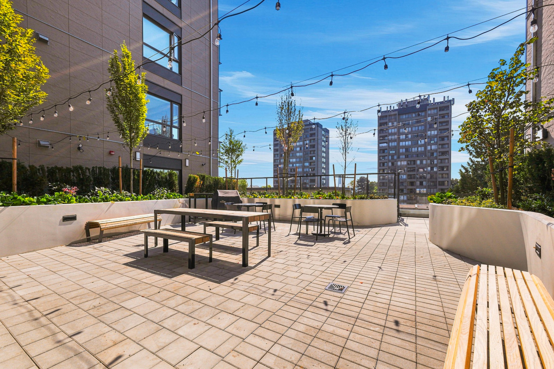 First & Royal second BBQ and gathering area with picnic seating, string lights and planters, New Westminster